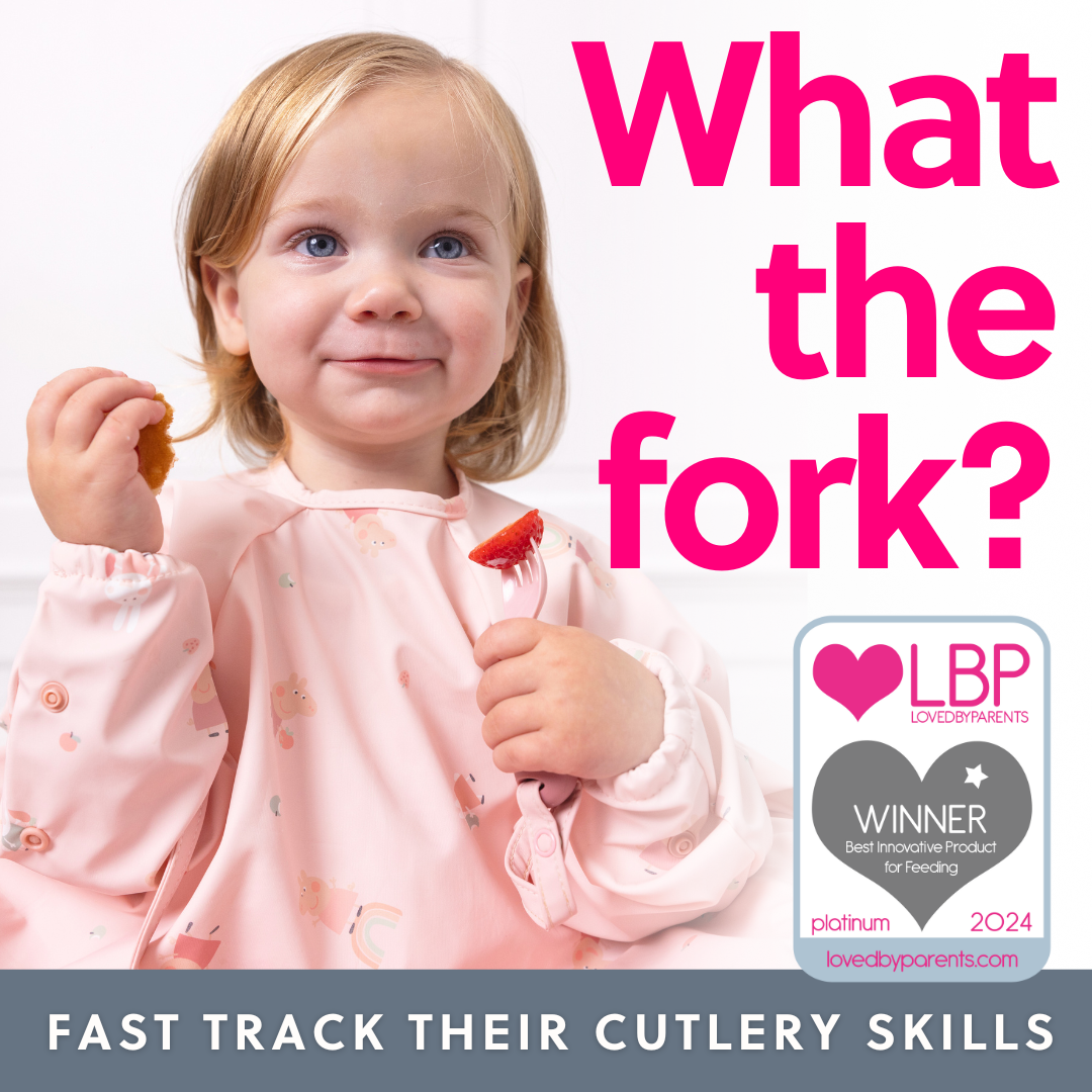 Smiling toddler in a pink bib, holding a fork with a strawberry and a piece of food.