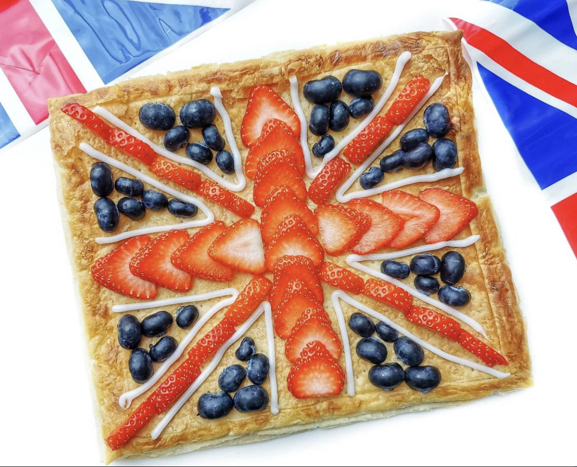 Puff pastry tart decorated with strawberries, blueberries, and white icing to resemble the Union Jack.