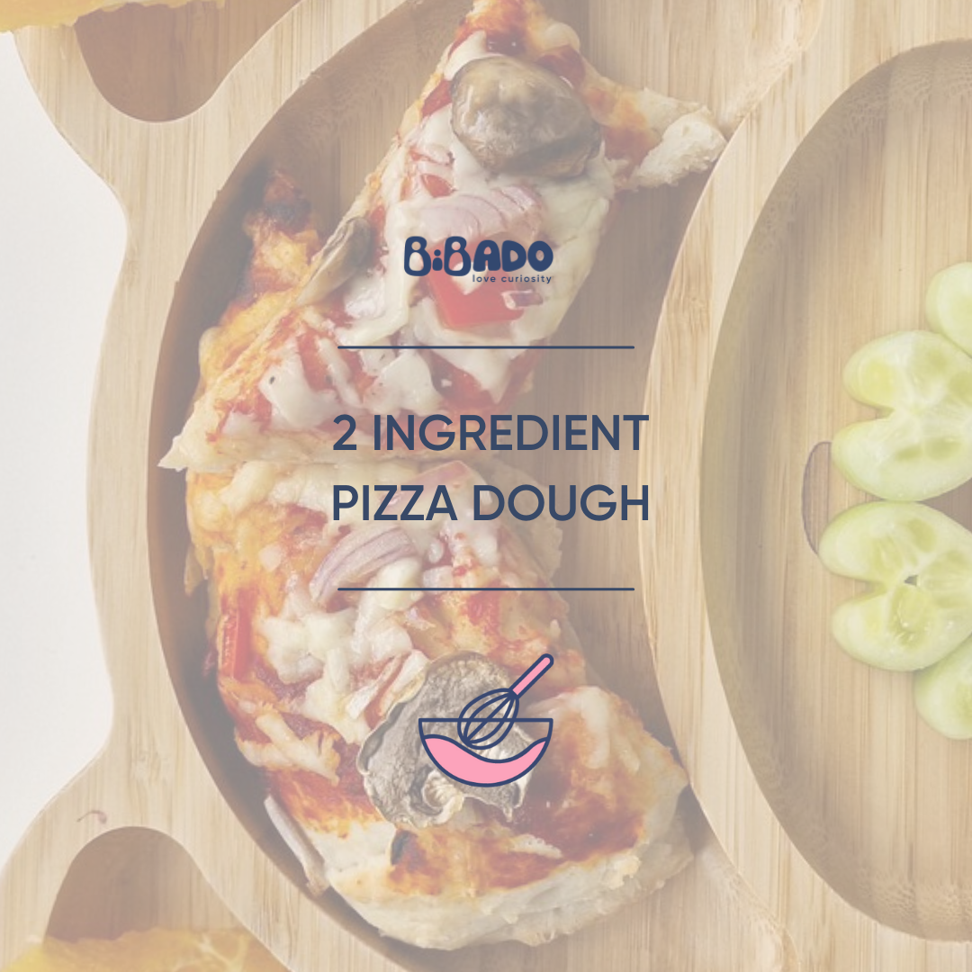 Two slices of pizza with mushrooms and red onion on a bamboo plate, next to cucumber slices.