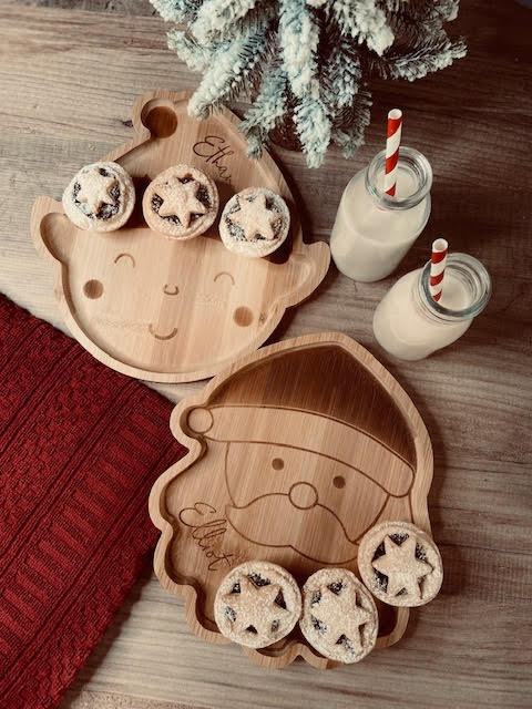 Festive mince pies on personalised wooden Santa and elf plates with milk for Christmas Eve.