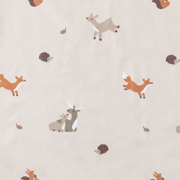 Beige long-sleeve coveralls with a playful forest animal print including deer, foxes, and hedgehogs. - Product image