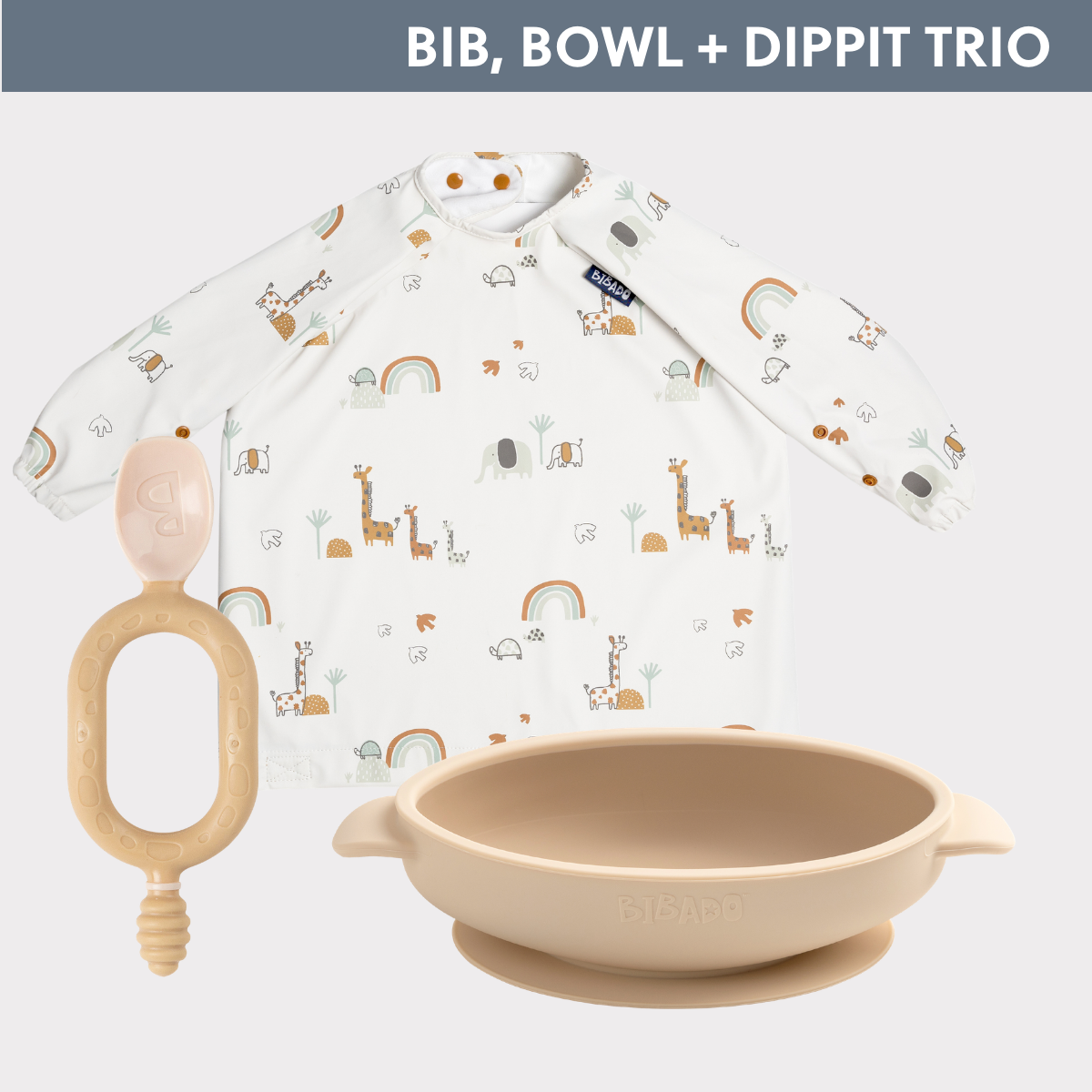 White long-sleeved weaning bib with animal print, beige silicone suction bowl, and matching Dippit spoon. - Product image