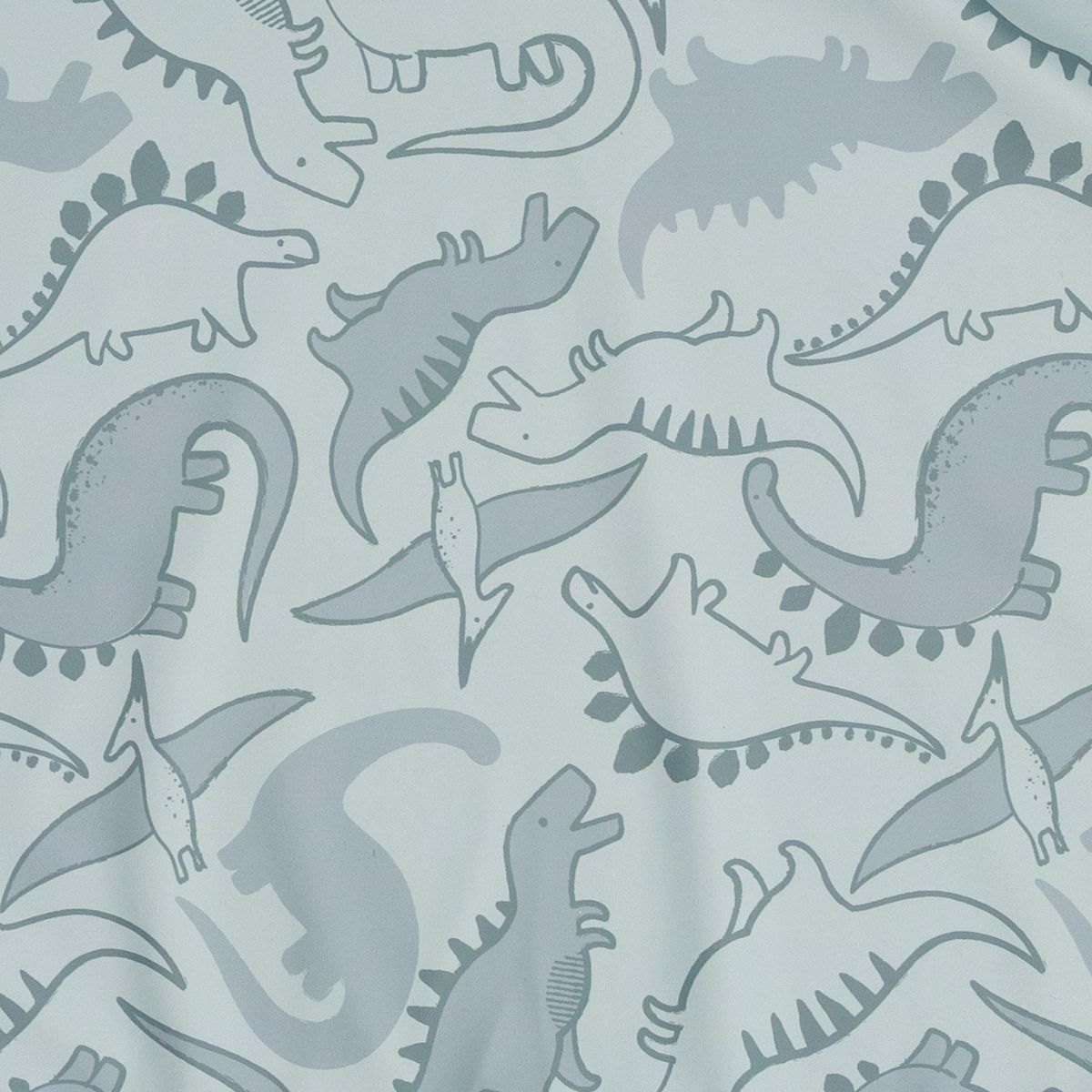 Close-up of a light blue fabric with a playful pattern of various grey and white dinosaur outlines. - Product image