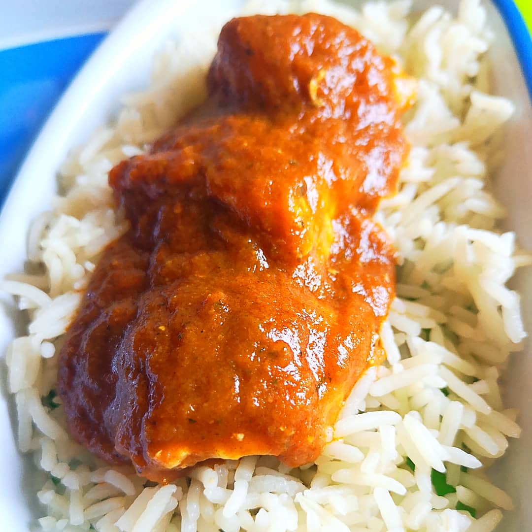 Creamy slow cooker butter chicken with a rich orange sauce served over fluffy white rice.