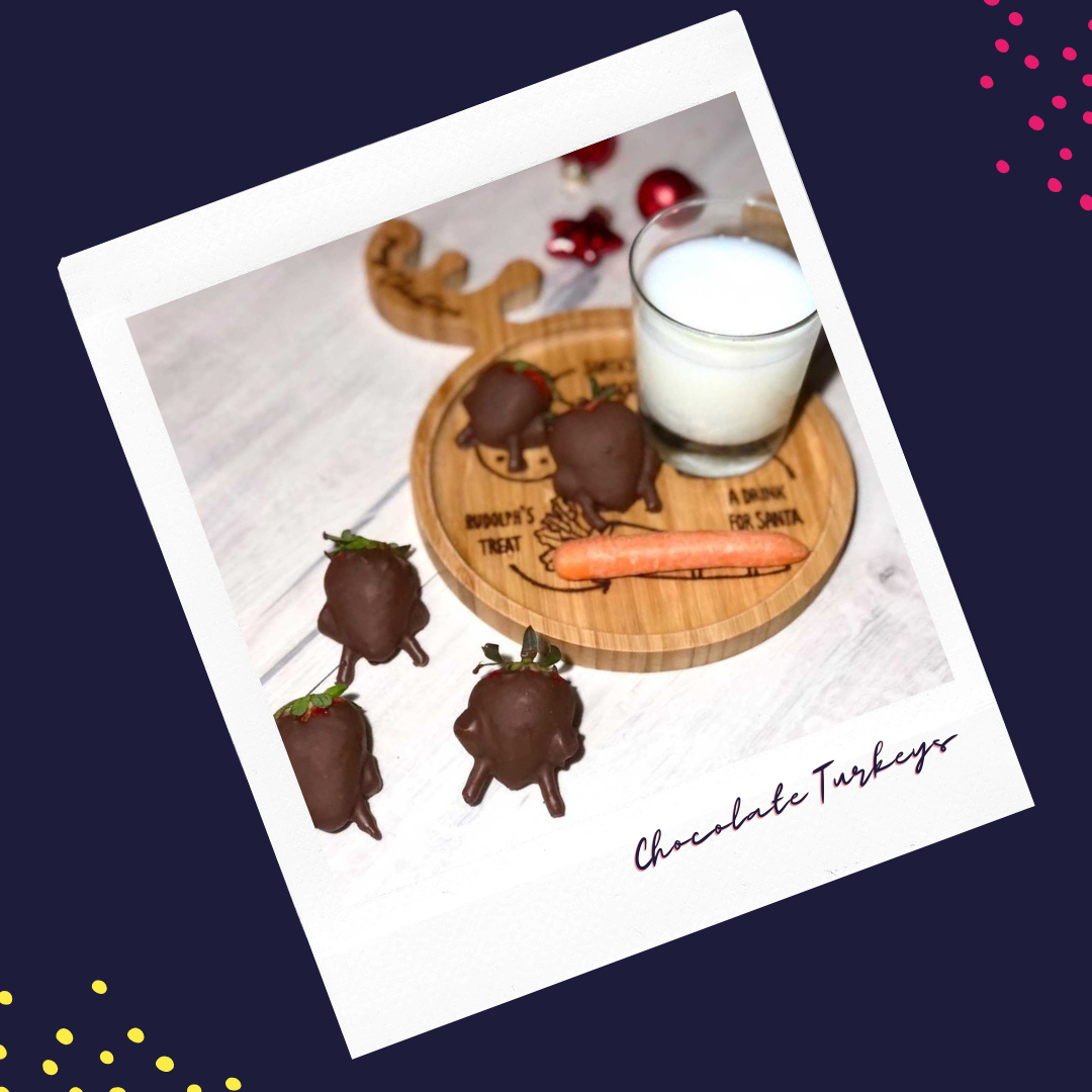 Chocolate-dipped strawberry turkeys on a wooden reindeer plate with milk and a carrot.