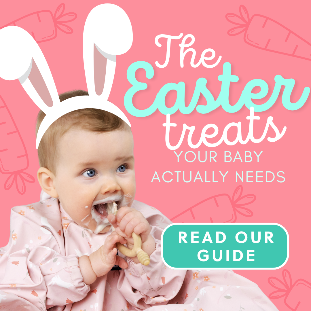 Happy baby in bunny ears and bib, weaning with a wooden teether and messy mouth.