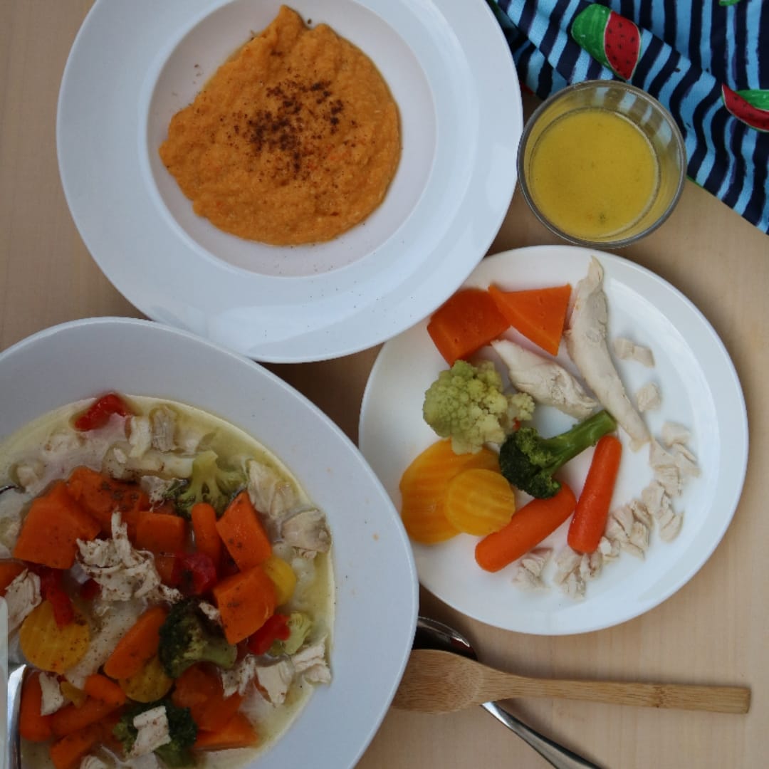 Creamy chicken soup with colourful vegetables, pureed carrots, and a side of broth.