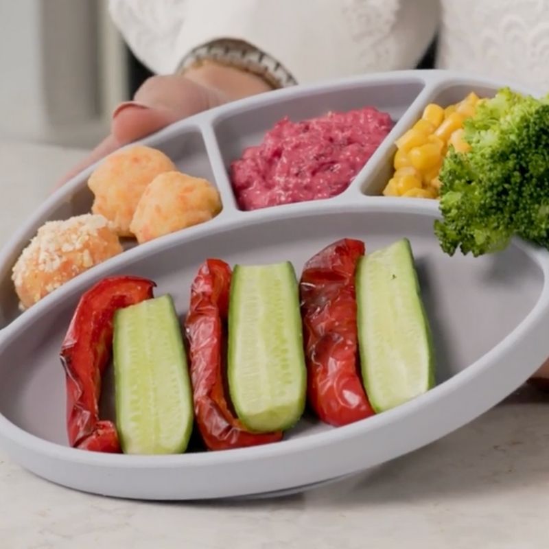 Baby's partitioned plate with colourful vegetables: broccoli, sweetcorn, beetroot purée, cucumber, and roasted pepper.