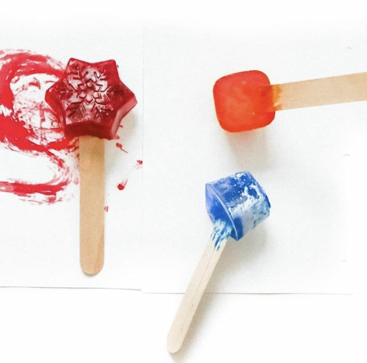 Red snowflake, orange square, and blue cube ice paint pops on white paper.