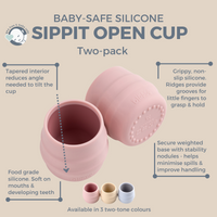 Baby's hand reaching for raspberries next to a pink Sippit silicone open training cup on a white highchair tray. - Product image