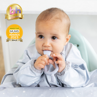 Three silicone Dippit™ or Sporkit™ baby spoons in pink, beige, and lavender, surrounded by yogurt and strawberries. - Product image