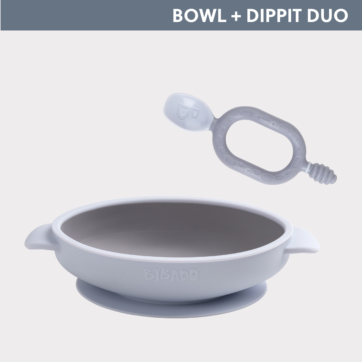 Light grey silicone baby bowl with suction base and matching ergonomic Dippit spoon. - Product image