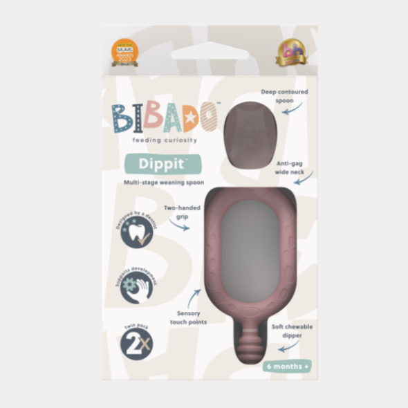 Pink Dippit™ multi-stage baby spoon and textured dipper in packaging, showing two-handed grip and deep contoured spoon. - Product image