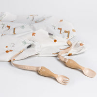 Bibado Handi Cutlery: beige fork and spoon with straps, attached to a white bib with animal print.