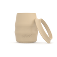 A beige silicone baby drinking cup with a removable silicone skirted base propped against it, shown on a clean white background. 