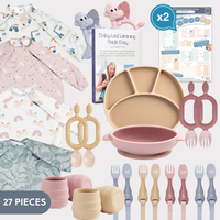 Twin tableware bundle with pink and beige silicone plates, bowls, cups, cutlery, dinosaur teethers, and patterned weaning bibs. - Product image