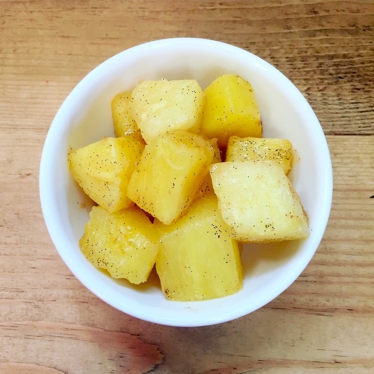 Small white bowl filled with golden roasted potato chunks, lightly seasoned with black pepper. - Product image